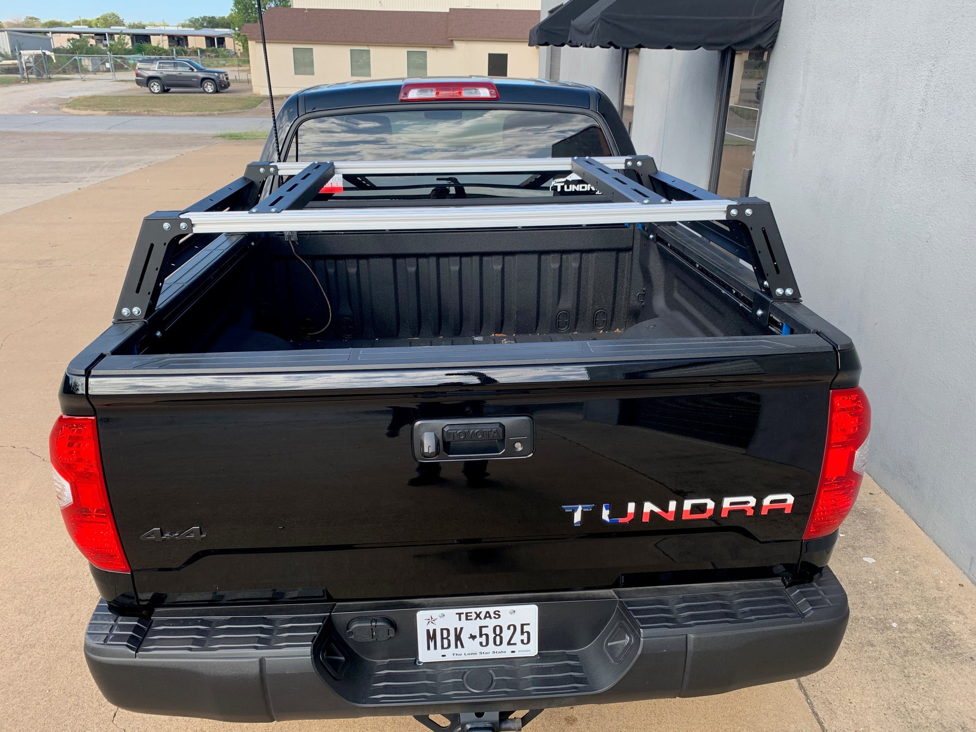 Rear view of black Toyota Tundra with Overland Bed Rack - Cali Raised LED
